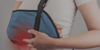 Person wearing a blue arm sling for injury support. Person wearing a blue arm sling for injury support.